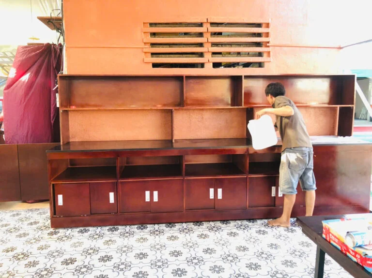 Thợ đang xử lý bề mặt hệ tủ trưng bày nhiều khoang tại công trình Bluecons