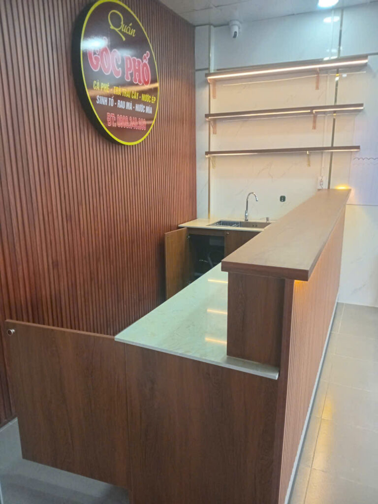 Góc dọc quầy MDF vân gỗ có mặt bàn phục vụ và khu rửa tại Quận 7
