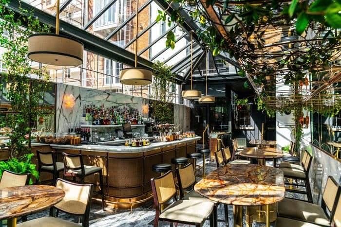 Thiết kế quán ăn ngoài trời có sân vườn và khu vực bar trang trí bằng hoa và cây xanh